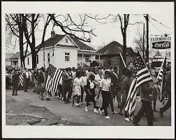 Participantes portando banderas estadounidenses en la marcha por los derechos civiles de Selma a Montgomery, Alabama, 1965.
Fotografía de Peter Pettus; copia en gelatina de plata (reimpresión de 1999–2000).         
Imagen de archivo en dominio público, cortesía de la División de Impresos y Fotografías de la Biblioteca del Congreso.